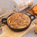 黑色鑄鐵鍋盛裝金黃色肉鬆，點綴著小片南瓜條，放置在木質砧板上.