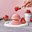 草莓口味慕斯蛋糕堆疊擺放，旁邊有新鮮草莓和白色瓷罐裝飾.