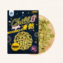黑色包裝紓壓凍乾貓零食，內含綠色方塊狀雞肉凍乾塊，旁邊木盤展示產品內容.