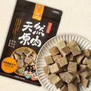 黑色包裝山味凍乾寵物零食，旁邊白色盤子盛裝方形肉塊.