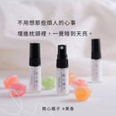 三瓶透明玻璃睡眠噴霧瓶，標籤寫著愛睡香氛與關心橘子果香，背景柔和淺色布料與彩色花瓣裝飾.