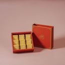 紅色方形禮盒內含九入金黃色包裝鳳梨酥，盒蓋設有金邊裝飾和品牌字樣.