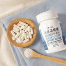 白色膠囊與白色瓶蓋保健品瓶，標籤顯示泌尿道健康保養粉，木製湯匙盛粉末，放置於藍色布料上.