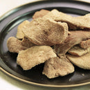 黑色陶瓷盤中堆疊的凍乾牛肉片，表面乾燥有層次感.