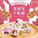 蔓越莓牛軋糖塊，白色牛軋糖內含杏仁和蔓越莓果乾，擺放於木盤上.