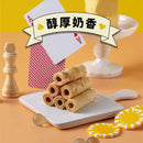 六條堆疊法式手工奶油蛋捲擺放於白色方形盤上，背景有黃色奶油塊和撲克牌裝飾.