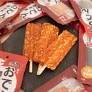 三支棕紅色關東煮雞肉乾棒插木棒，周圍散落紅白包裝袋.