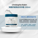 Christophe Robin 海鹽舒緩頭皮潔淨霜 250ml 的產品宣傳圖。左側展示白色圓罐、藍綠色瓶蓋的頭皮潔淨霜，放置在白色圓形底座上，背景有海鹽結晶的意象。右側配有中文文宣，強調地中海天然海鹽能溫和潔淨毛囊、深層淨化，並標註適合油性頭皮、機車族及頭皮易悶熱發癢者使用。