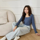 玄青色方領長袖保暖衣，輕薄貼身，搭配淺色牛仔褲 sitting pose.