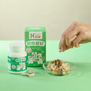 綠色包裝狗貓眼睛保健品30顆膠囊，旁邊有透明碟盛裝寵物食物，手指拿取膠囊.