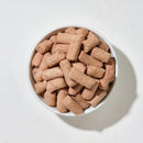 白色碗中裝滿淡棕色犬用凍乾雞肉條狀零食.