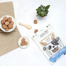 KiWiPet 袋鼠肉餅犬貓凍乾零食袋裝，旁有白色陶瓷碟與木匙展示產品餅乾.