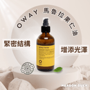 棕色玻璃瓶裝Oway馬魯拉果仁油護髮油，帶黑色噴頭，黃色標籤，背景柔和光影.