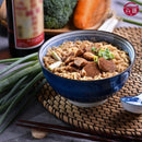 藍色碗內花雕東坡肉麵，麵條與豐富肉塊，蔥花點綴，搭配筷子和醬料碟.