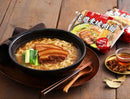 黑色碗中盛有花雕東坡肉麵，配有三層肥瘦相間的東坡肉與青菜，放置木質托盤上，旁邊擺有筷子和調味包.